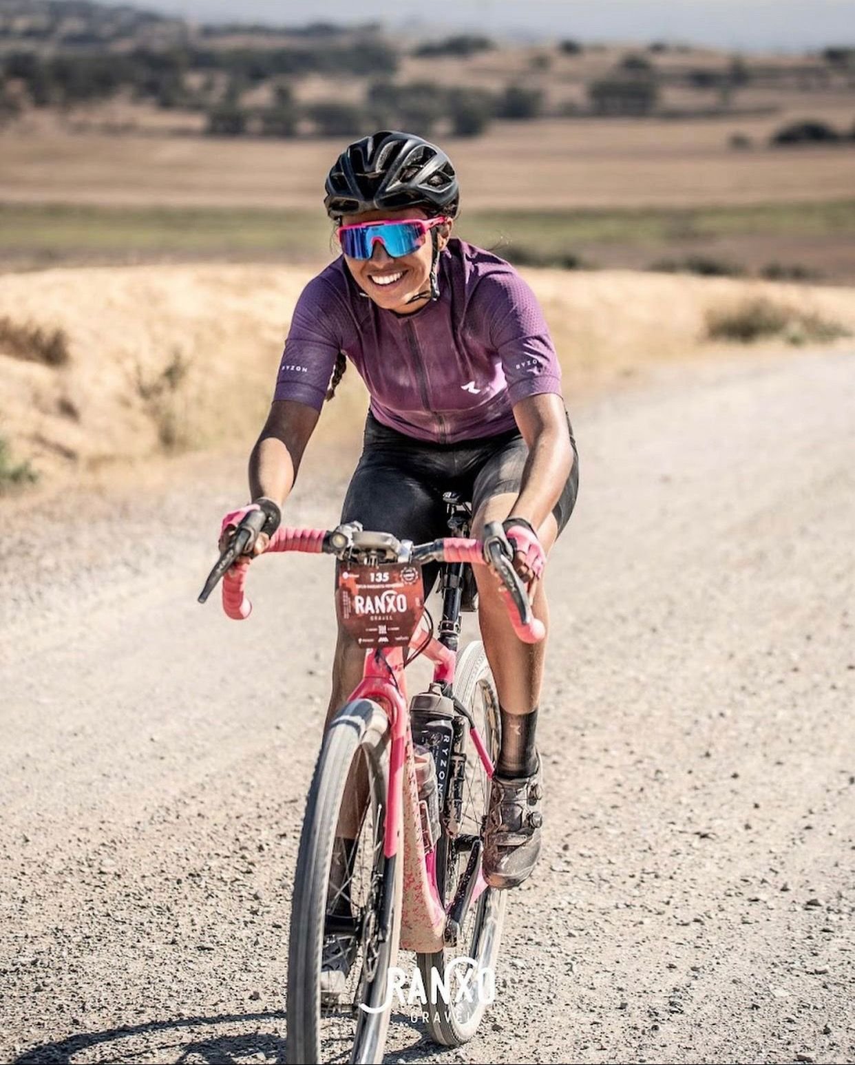 Daylin Miller, co-founder of Middle Ground Cycling, smiling as she competes in the Ranxo Gravel Race—showcasing her strength, skill, and passion for gravel cycling in Spain.